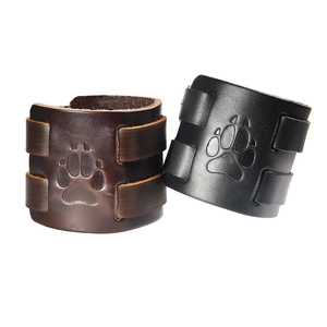 Set of two vintage leather wristbands with embossed animal paw print and metal rivets