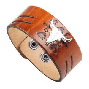 Brown leather cuff bracelet featuring a silver metal bull skull and tribal engravings