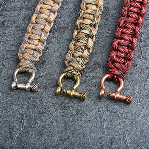 Braided paracord bracelet with skull accent and metal U-shackle in three colors
