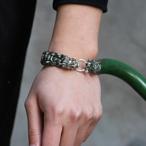 Army green paracord survival bracelet with detailed silver Indian head metal buckle