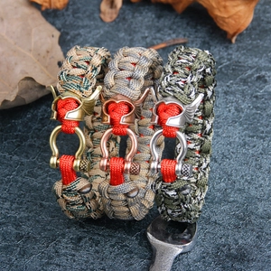Trois bracelets de survie en paracorde avec perles de casque nordique sur fond de pierre