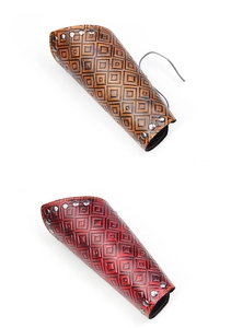 Detail view of vintage embossed leather vambraces with square patterns and metal rivets