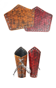 Vista macro de protectores de brazo de cuero gótico con calaveras grabadas y remaches de metal