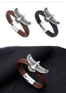 Close-up of men's leather braided bracelet with detailed eagle wing charm and magnetic clasp