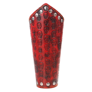 Muñequera punk de cuero rojo con calaveras grabadas y remaches metálicos plata