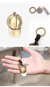 Detail of vintage bronze baseball cap keychain with leather rope and engraved metal charms
