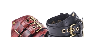 Detail of vintage punk leather bracelets with brass buckles and rivets in black and red