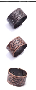 Makro-Detail von braunem Lederarmband mit Paisley-Prägung und türkisfarbenen Akzenten
