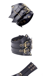 Detailed view of punk wide leather wristband with bronze buckles and metal rivets
