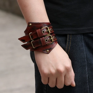 Retro rock style brown leather bracelet with double bronze buckles and metal rivets on wrist