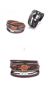 Détail d'un bracelet multicouche en cuir bohème avec perles, cristaux et fermoir magnétique