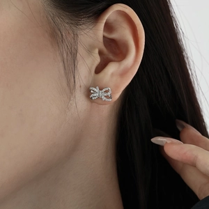 S925 sterling silver bow earrings with sparkling cubic zirconia on female model