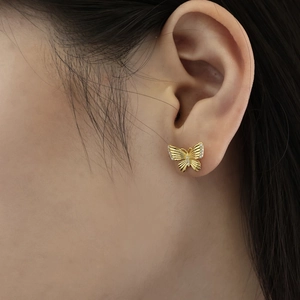 Detailed close-up of butterfly stud earring featuring gold finish and sparkling zircon stones