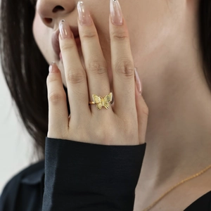 Detailed view of a golden butterfly ring featuring textured wings and sparkling zircon accents