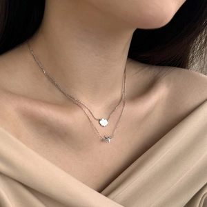 Close-up of S925 sterling silver layered necklace with plane and cloud pendants on neck