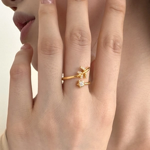 Detailed close-up of a gold airplane and star ring with sparkling zircon inlay