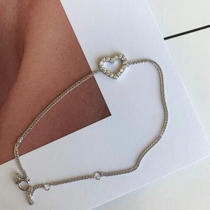 Detailed macro view of an S925 silver heart bracelet with sparkling pavé-set crystals