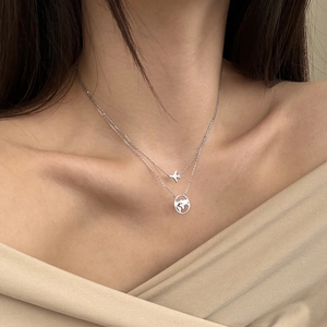 Detail view of S925 silver double necklace featuring airplane and hollow world map pendants