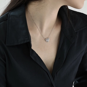 Gros plan du collier coeur en argent S925 avec zircon rose sur un mannequin en noir