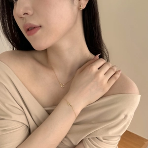 Close-up of elegant gold airplane jewelry set with sparkling zircon on a female model
