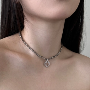 Detail of S925 silver necklace featuring beaded chain and pavé clover pendant on skin