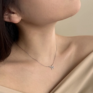 Close-up of S925 sterling silver airplane pendant necklace with zircon inlay on neck