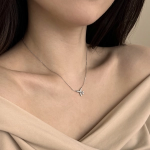 Macro shot of S925 sterling silver airplane pendant necklace set with zircon stones