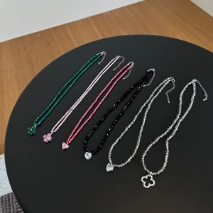 Macro detail of S925 silver beaded necklaces with clover and heart crystal pendants
