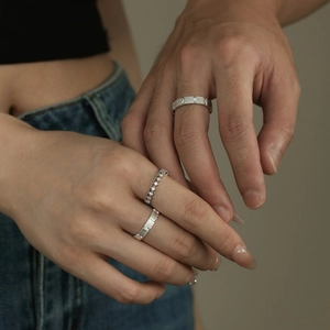 Close-up of S925 sterling silver couple rings with brushed texture and zircon details