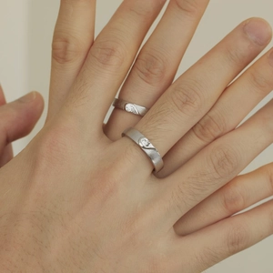 Close-up of S925 silver couple rings with matte finish and matching heart detail