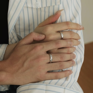 Close-up of S925 silver couple rings forming a heart shape with matte finish and zircons