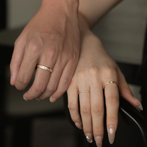 Macro detail of rose gold matching couple rings with matte finish and diamond accents