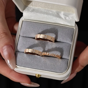 Macro shot of rose gold rings with frosted texture and crown design in jewelry box