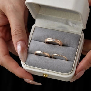 Detailed view of matte rose gold rings with white zircon in a luxury jewelry box
