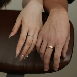 Close-up of rose gold couple rings featuring pavé diamonds and brushed matte finish