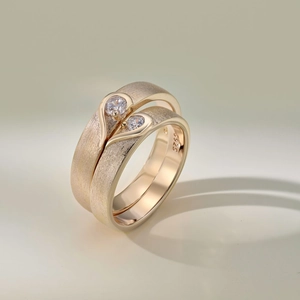 Macro detail of S925 sterling silver couple rings with brushed gold finish and heart stones