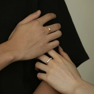 Detail of rose gold couples rings featuring brushed finish and sparkling pavé stones