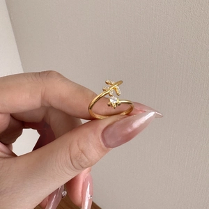 Detail van een vergulde verstelbare ring met een kruislings ontwerp bezet met zirkoon