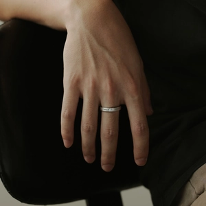 Macro view of minimalist S925 silver ring with brushed finish and centered round diamond