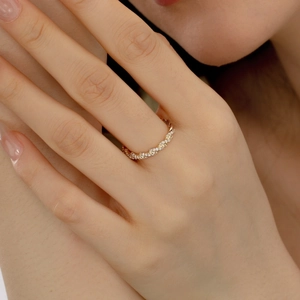 Détail de la bague en or torsadée avec pierres de zircon sur le doigt d'une femme