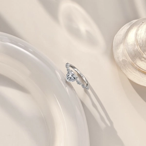 Macro detail of S925 sterling silver ring with heart-shaped zircon on white ceramic