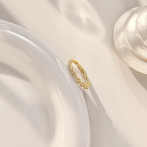 Détail d'une bague tressée en argent S925 doré avec incrustation de pierres zircon