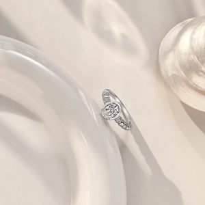 Detail of S925 silver ring with oval ice-cut zircon on elegant white ceramic plate