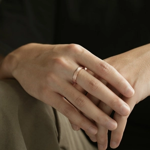 Macro detail of rose gold brushed matte finish ring band on finger for men and women