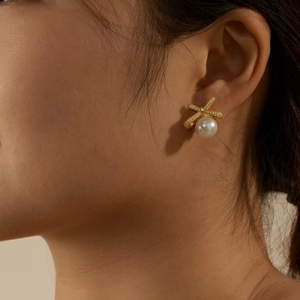 Detail of S925 silver bow stud earrings with sparkling zircon and pearl inlay