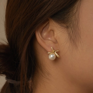 Elegant gold bow earrings with shimmering cubic zirconia and a round white pearl drop