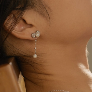 Elegant S925 silver bow earrings with long tassels and pearls worn by a model