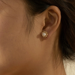 Classic S925 silver flower stud earrings with pearl and zircon inlay worn on ear