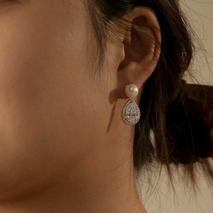 Macro shot of S925 silver teardrop earrings with pearl stud and cubic zirconia detail