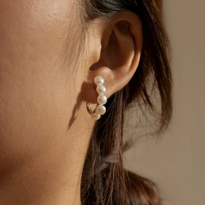 Close-up of S925 silver hoop earrings with five vertical freshwater pearls on model ear